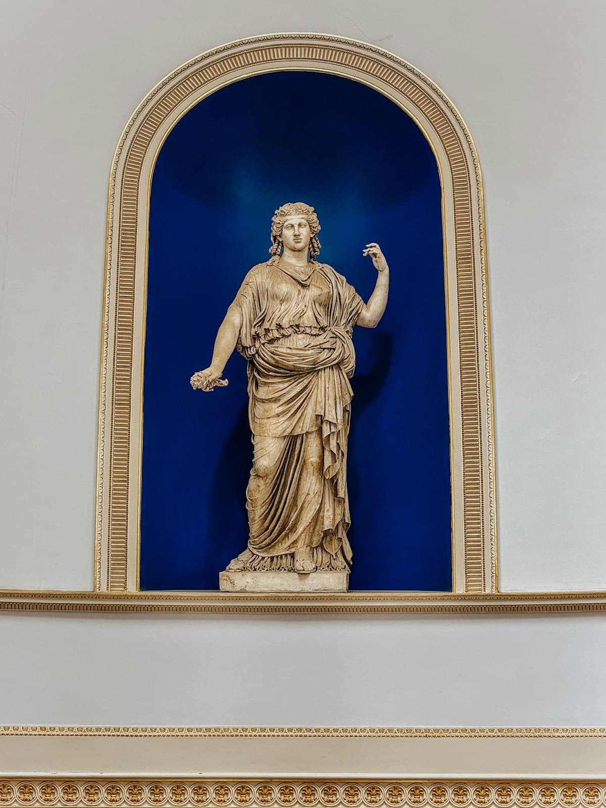 A marble statue in a blue alcove